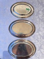 Top view of three silver-plated trays showing marks and finish
