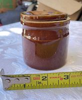 Jar with tape measure showing height around 2.5 inches