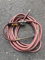 Coiled red air hose with fittings and blow gun nozzle