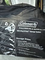 Close-up of Coleman Wrap 'N' Roll airbed storage bag showing branding and instructions