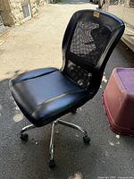 Front side view of black mesh office chair with chrome base and casters