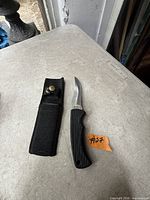 Knife and sheath on table with lot tag visible