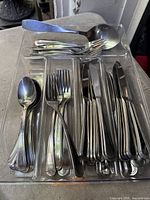 Entire lot showing stainless cutlery sorted in lucite tray