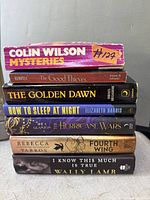 Stack of seven books showing titles and authors