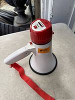 Top angle showing white/red megaphone, control switches, strap attachment