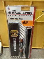 Front view of sealed Mini Maglite Pro+ LED flashlight package showing flashlight, batteries, lumen rating
