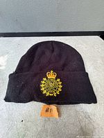 Front view of black beanie showing embroidered O.P.P. crest