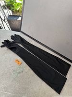 Pair of long black evening gloves laid flat showing full length and finger detail