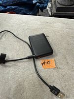Black power bank with attached cable and red LED