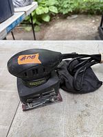 Power It palm sander showing full unit, dust bag, cord and sanding base