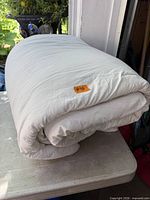 Folded white queen comforter placed on a table