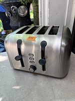 Front view of stainless steel Oster four-slice toaster showing controls and slots