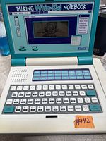 Notebook open showing keyboard, screen displaying graphic, function keys visible