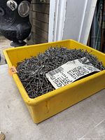 Yellow tray filled with loose spiral shank nails