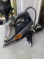 Full view of Black+Decker steam iron with cord and plug visible
