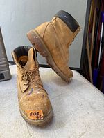 Pair of Timberland boots, one upright one tilted showing exterior wear and paint spots