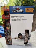 Front of unopened Napoleon BBQ Smoking Starter Kit box showing contents