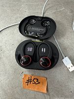 Earbuds seated in open charging case showing LED indicators