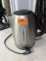 Stainless steel TRU electric kettle showing water gauge, cord and handle