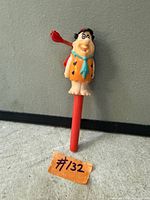 Front view of Fred Flintstone propeller pen showing character details and red barrel