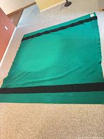 Full blanket laid flat showing green field and central black stripe