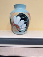Front view of light blue ceramic vase showing floral and geometric design