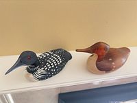 Both wooden bird decoys side by side