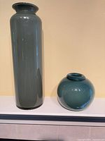 Tall and round vases side by side on mantle