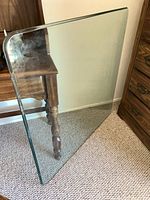 Full view of square glass tabletop leaning against furniture