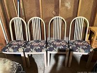Front view of all four cream wood chairs with floral seats