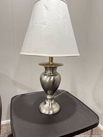 Full view of lamp on table showing base and shade