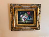 Full view of framed floral oil painting hung on wall