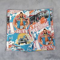Front view of folded A-Team patchwork shorts showing graphics and drawstring