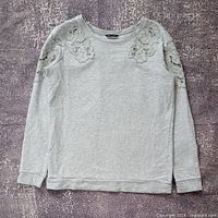 Front view of gray embroidered long sleeve top laid flat