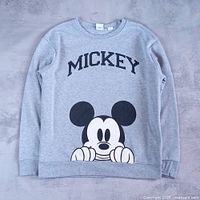 Full front view of grey Mickey Mouse crewneck laid flat