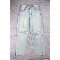 Full front view of light wash distressed jeans laid flat