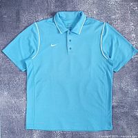 Full front view of the blue Nike Dri-FIT polo shirt