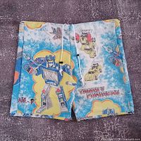Front view of reworked Transformers shorts showing overall design, drawstring, graphics, and patch
