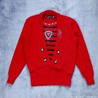Full view of red layered sweater laid flat showing overall design and condition