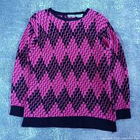 Full front view of sweater laid flat showing pattern and overall condition