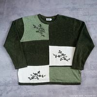 Full front view of patchwork green and white embroidered sweater