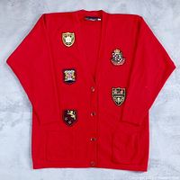 Full view of red cardigan front showing patches, buttons, pockets
