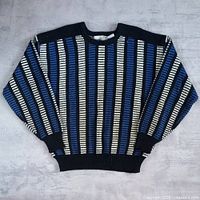 Full view of striped sweater laid flat showing overall design and condition