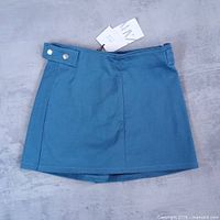 Front view of blue Zara mini skort with tag attached