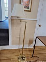 Full view of brass-tone floor lamp with shade