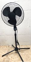 Full view of black 16" pedestal fan on tripod base