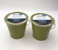 Two green 5-inch bucket citronella candles side by side