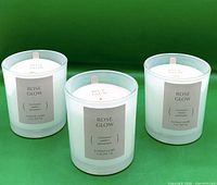 Front view of three Threshold Rose Glow candles showing labels