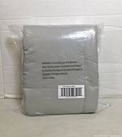 Folded gray blanket sealed in plastic bag