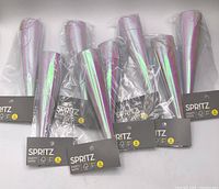 Eight sealed packs of Spritz iridescent party hats